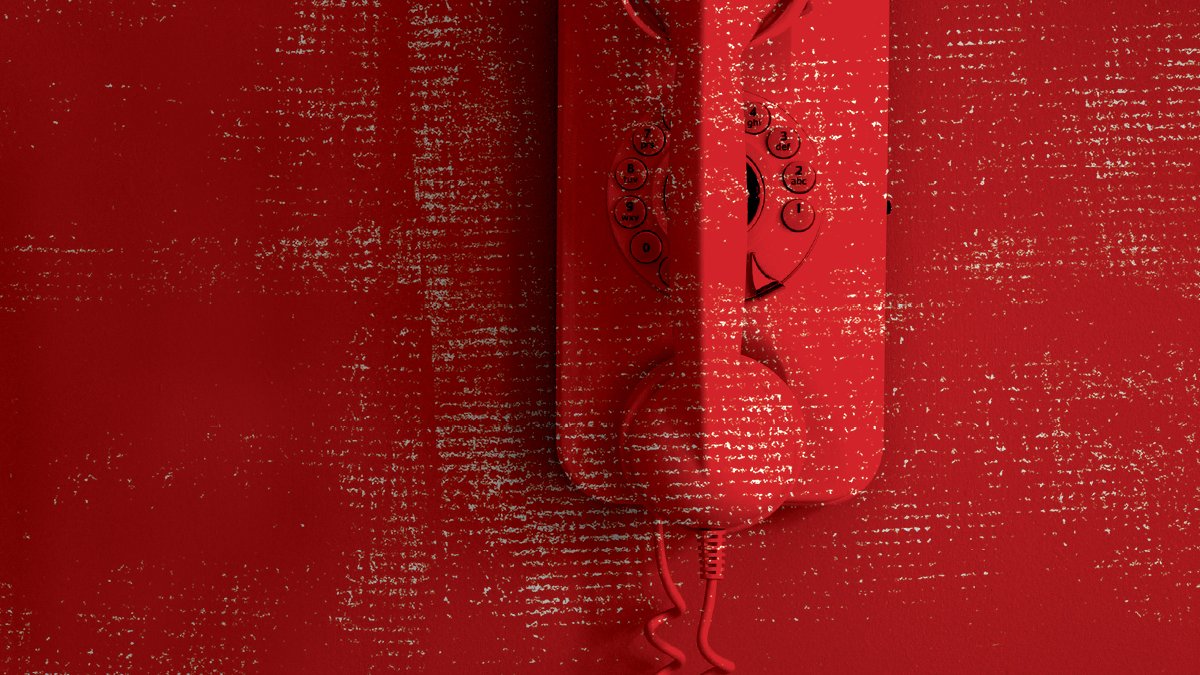 A red landline phone is positioned onto a matching red coloured wall.